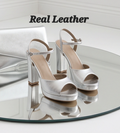 Silver platform sandals with 12cm heels by Monroe Lace, featuring a stylish open-toe design and ankle strap.