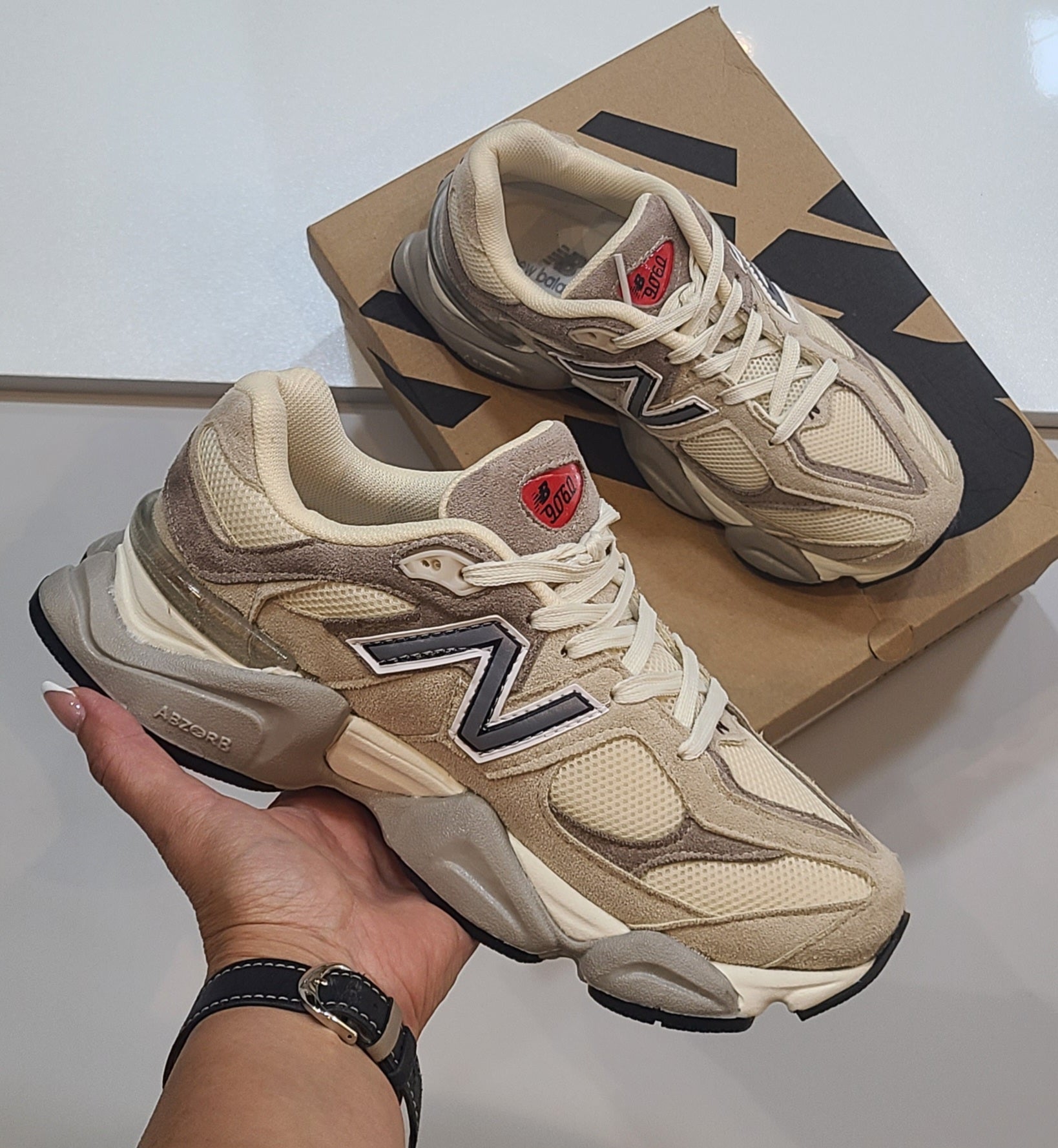 Monroe Lace New Balance 9060 sneakers featuring a sleek design with white and pastel accents, displayed on a plain background.