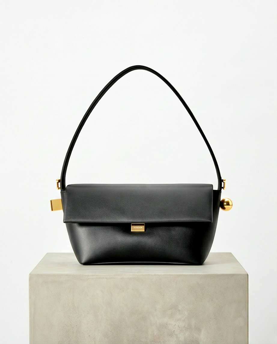 Small elegant handbag from Monroe Lace featuring a sleek design with top handles and subtle details.